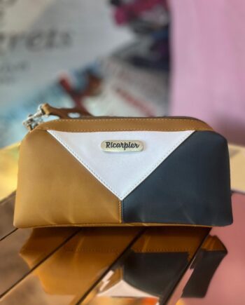 Neceser rectangular de la marca Ricarpier con diseño en bloques de color blanco, negro y marrón, ideal para viajar.